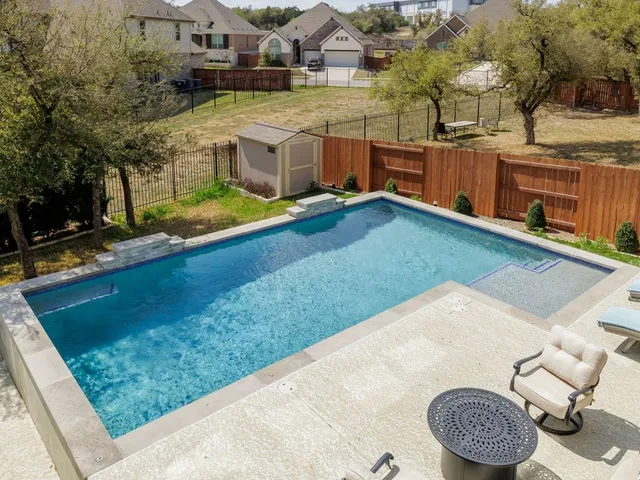 a view of backyard with swimming pool and sitting area