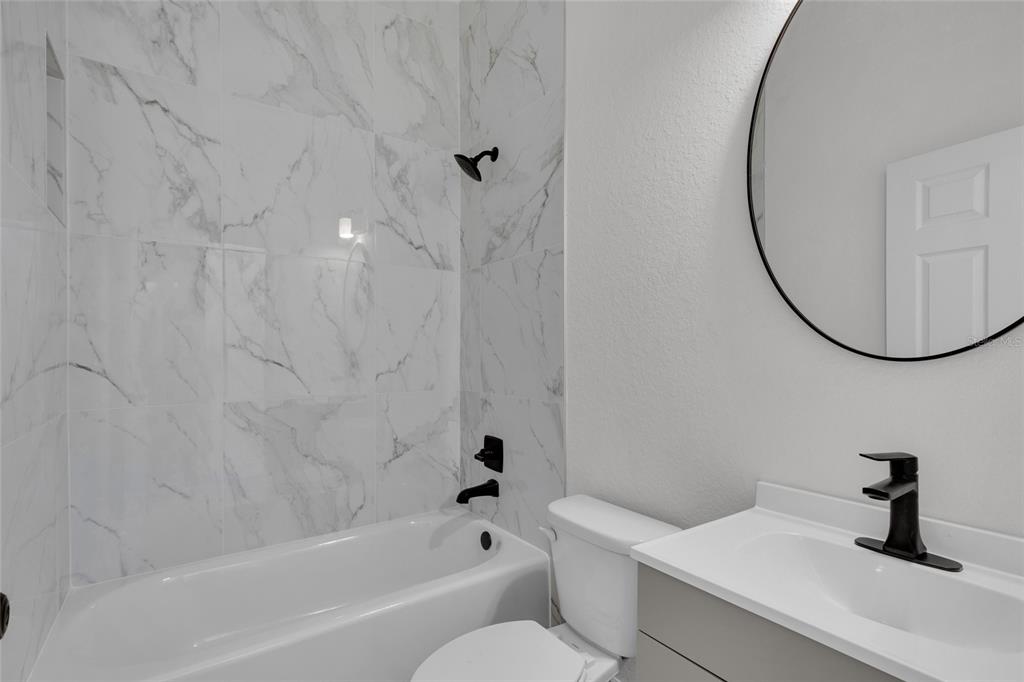 902 Southwest 2nd Street Ocala, FL 34471 - Photo 14 of 42 a bathroom with a sink a toilet and a mirror