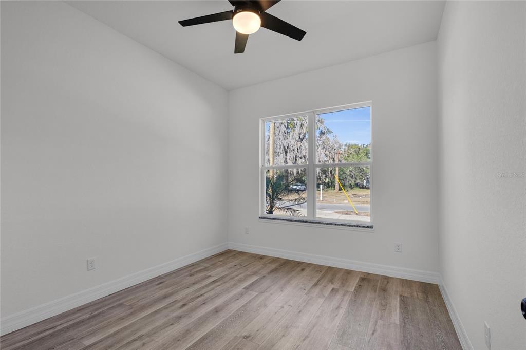 902 Southwest 2nd Street Ocala, FL 34471 - Photo 15 of 42 wooden floor in an empty room with a window