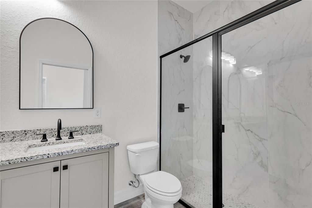 902 Southwest 2nd Street Ocala, FL 34471 - Photo 20 of 42 a bathroom with a granite countertop sink toilet and shower