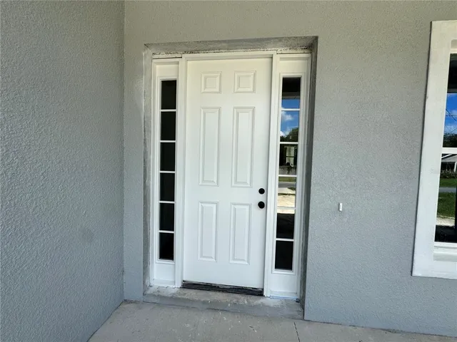 a view of empty room with wooden floor and window