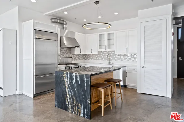 a kitchen with stainless steel appliances granite countertop a stove a sink and a refrigerator