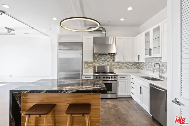 a kitchen with kitchen island granite countertop a stove and a refrigerator