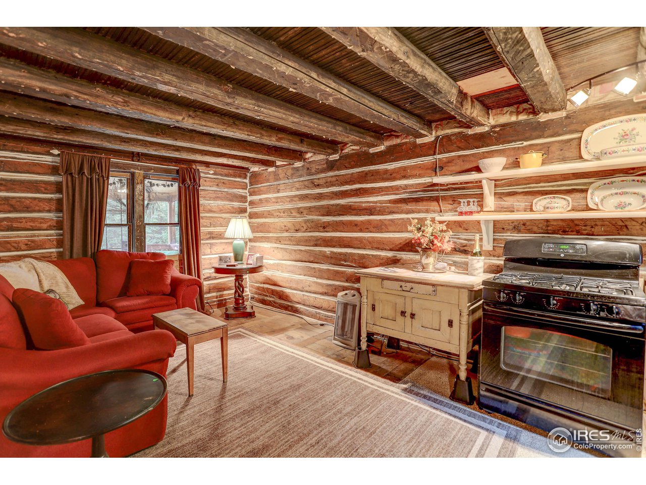 5672 Apex Valley Road Idaho Springs, CO 80452 - Photo 10 of 23 Living/kitchen area w/original log walls, hand-hewn rafters and wood flooring