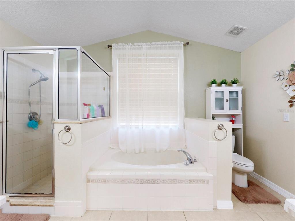 4775 Jay Drive St. Cloud, FL 34772 - Photo 19 of 49 a bathroom with a bathtub and a shower