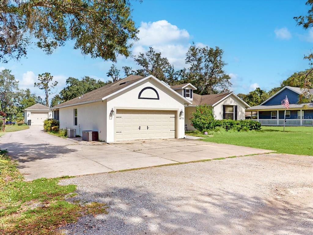 4775 Jay Drive St. Cloud, FL 34772 - Photo 2 of 49 a front view of a house with a yard and garage
