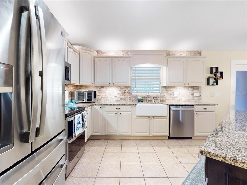 4775 Jay Drive St. Cloud, FL 34772 - Photo 7 of 49 a kitchen with a sink window and stainless steel appliances