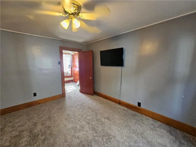 an empty room with closet and a chandelier fan