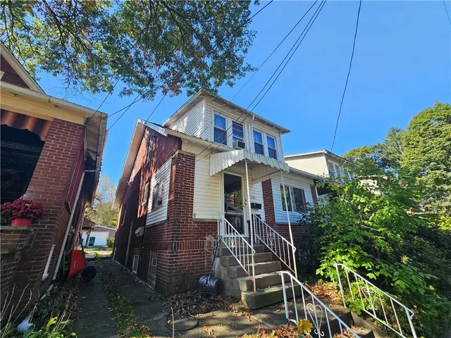a front view of a house with plants