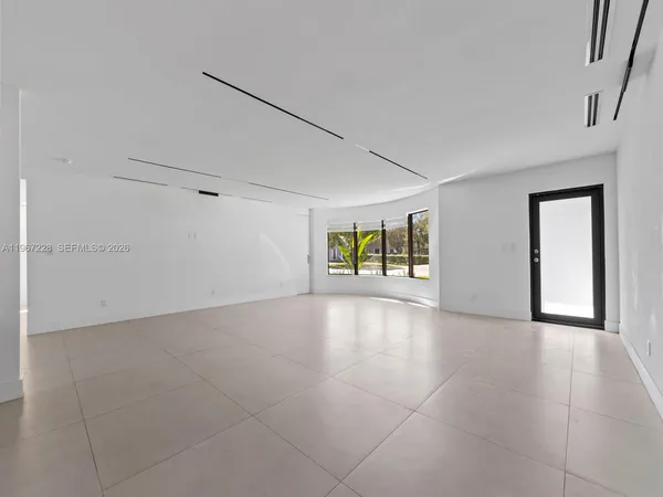 a view of empty room with window and refrigerator
