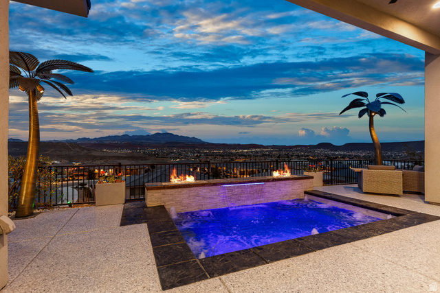 3022 West Sesia Way St. George, UT 84770 - Photo 2 of 52 Pool at dusk featuring a patio area, an outdoor pool, an outdoor fire pit, and a mountain view