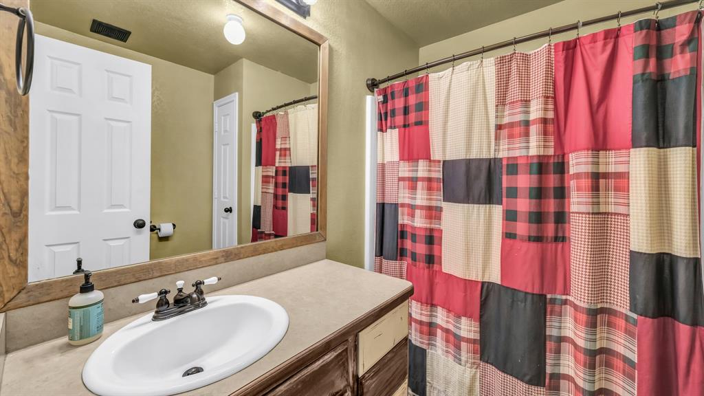111 Quail Drive Springtown, TX 76082 - Photo 13 of 22 a bathroom with a granite countertop sink and a mirror