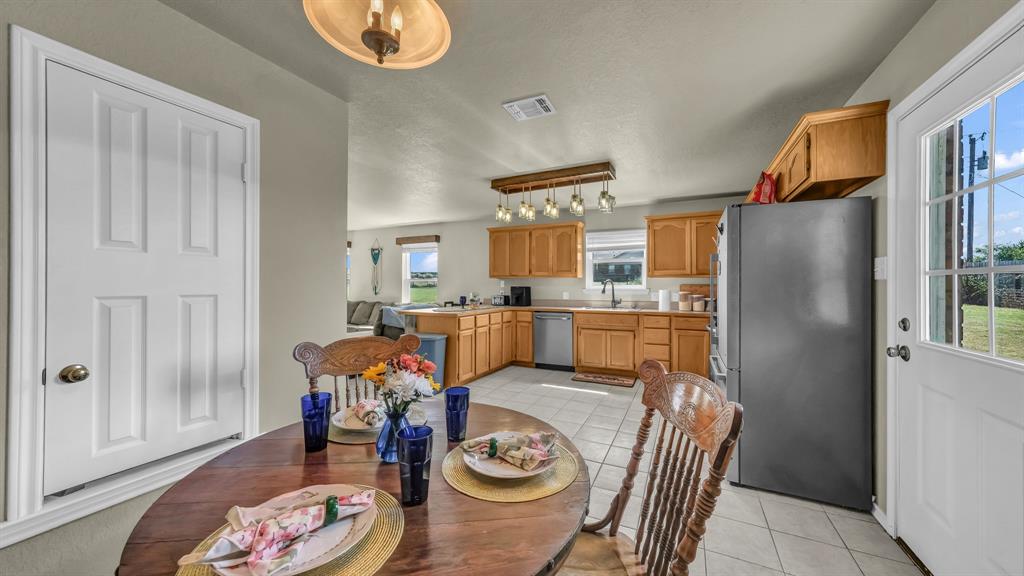 111 Quail Drive Springtown, TX 76082 - Photo 5 of 22 a dining room with furniture a rug and kitchen view
