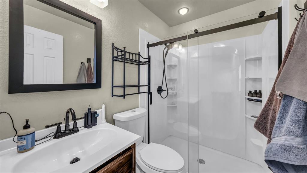 111 Quail Drive Springtown, TX 76082 - Photo 8 of 22 a bathroom with a sink vanity mirror and toilet