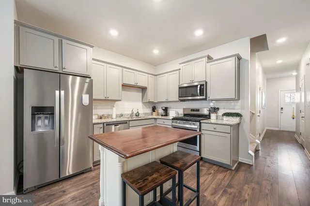 a kitchen with stainless steel appliances granite countertop a refrigerator stove microwave and sink