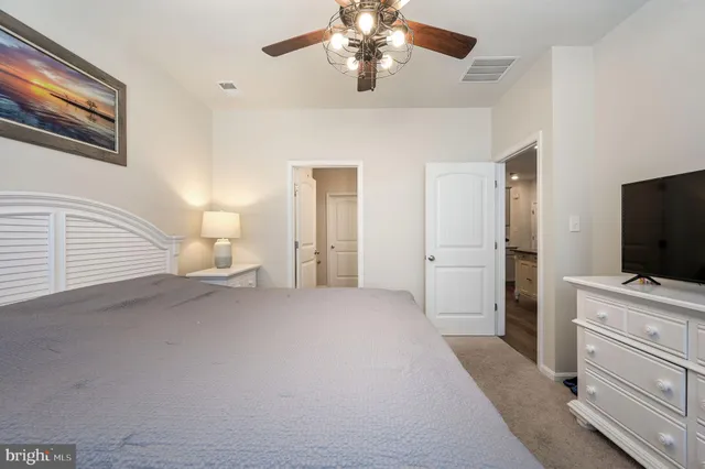 a bedroom with a bed and a flat tv screen on dresser