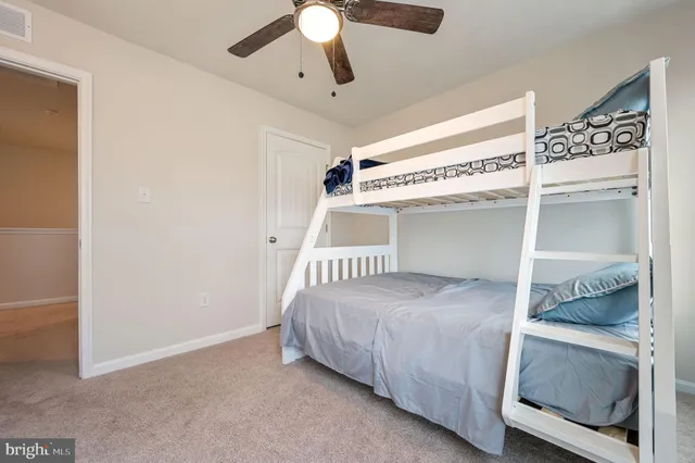 a bedroom with a bed and a chandelier fan