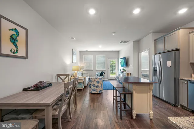 a view of a dining room with furniture a rug and wooden floor