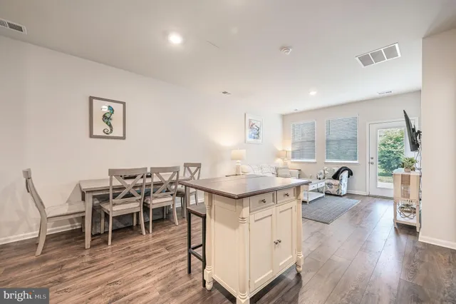 a open kitchen with stainless steel appliances granite countertop a stove and chairs with wooden floor