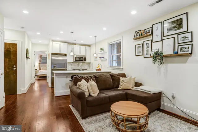 a living room with furniture and a dining table with wooden floor