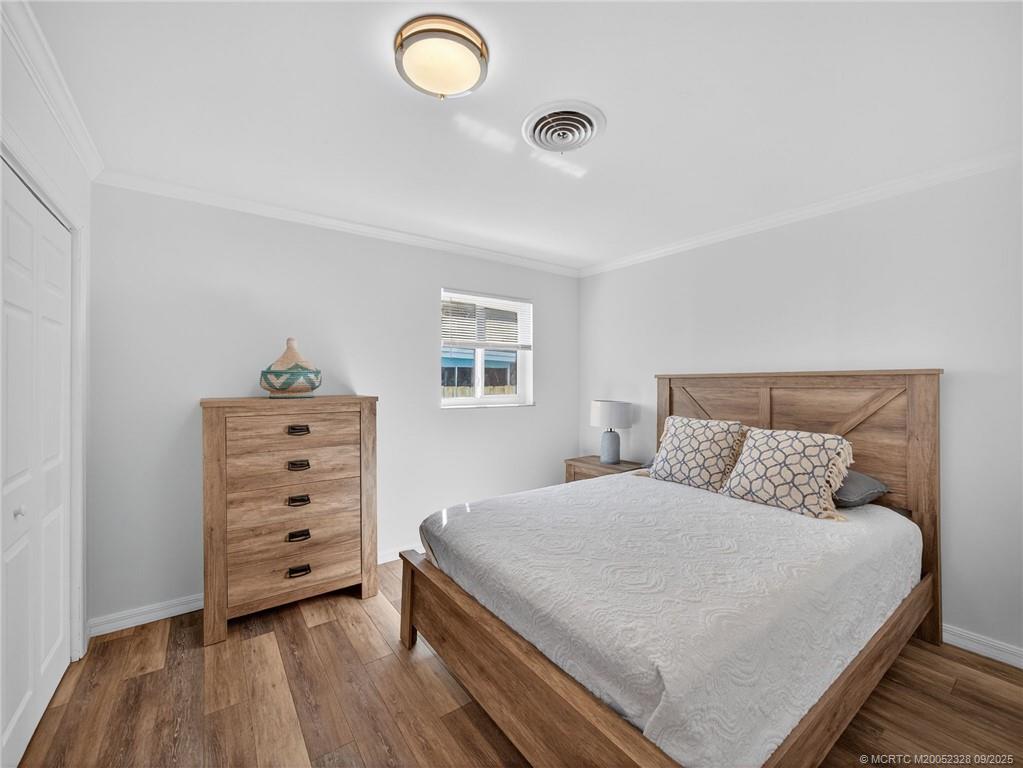 2346 Northeast Rustic Place Jensen Beach, FL 34957 - Photo 12 of 18 a bedroom with a bed and a dresser