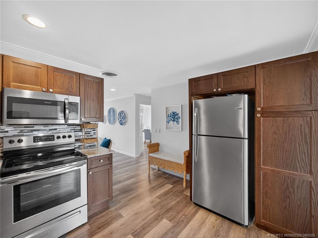 2346 Northeast Rustic Place Jensen Beach, FL 34957 - Photo 7 of 18 a kitchen with stainless steel appliances a refrigerator stove and microwave