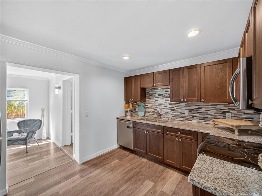 2346 Northeast Rustic Place Jensen Beach, FL 34957 - Photo 8 of 18 a kitchen with stainless steel appliances granite countertop a stove and a sink