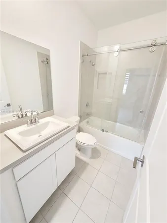 a bathroom with a double vanity sink toilet mirror and shower