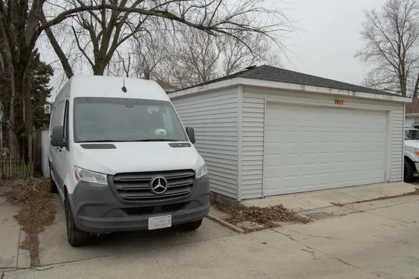 a view of a car parked in back yard of a house