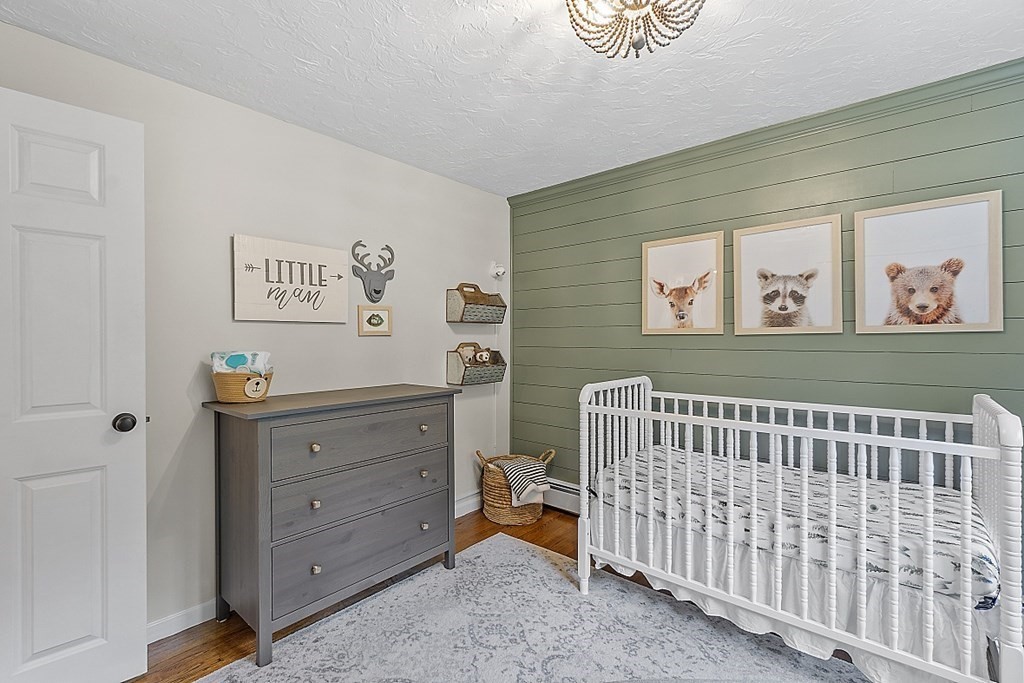 27 Tanglewood Road Sterling, MA 01564 - Photo 25 of 38 a bedroom with a baby bed a couch and a window