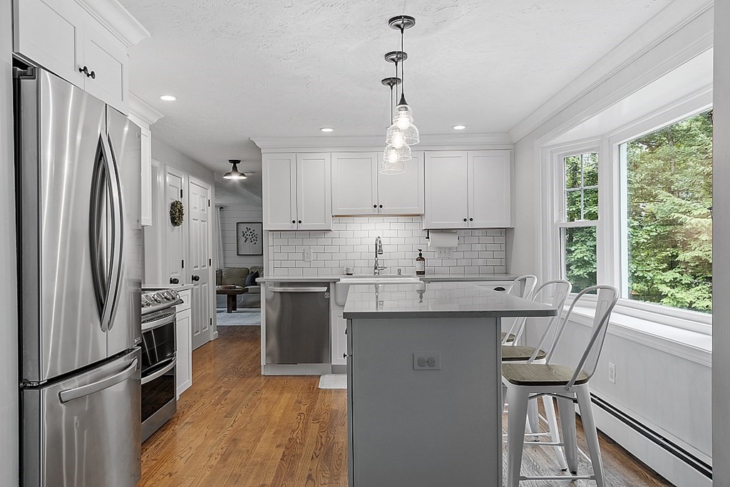 27 Tanglewood Road Sterling, MA 01564 - Photo 10 of 38 a kitchen with stainless steel appliances granite countertop a refrigerator a sink dishwasher a stove and white countertops with wooden floor