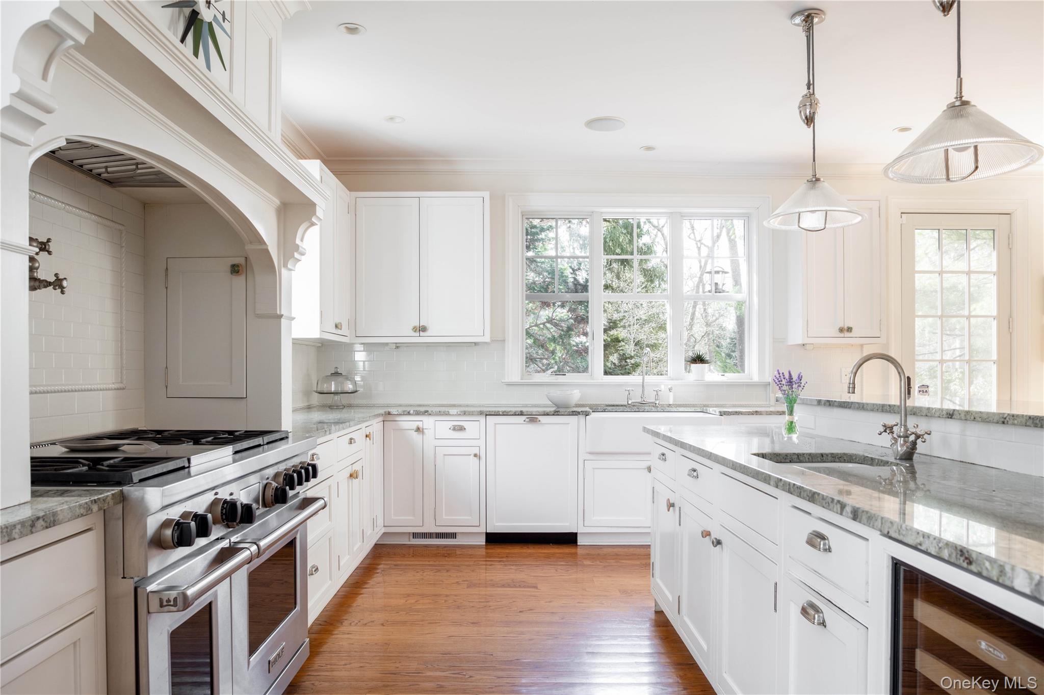 53 Cedar Lane West Remsenburg, NY 11960 - Photo 18 of 38 Kitchen featuring light wood-style flooring, beverage cooler, a sink, white cabinets, and range with two ovens