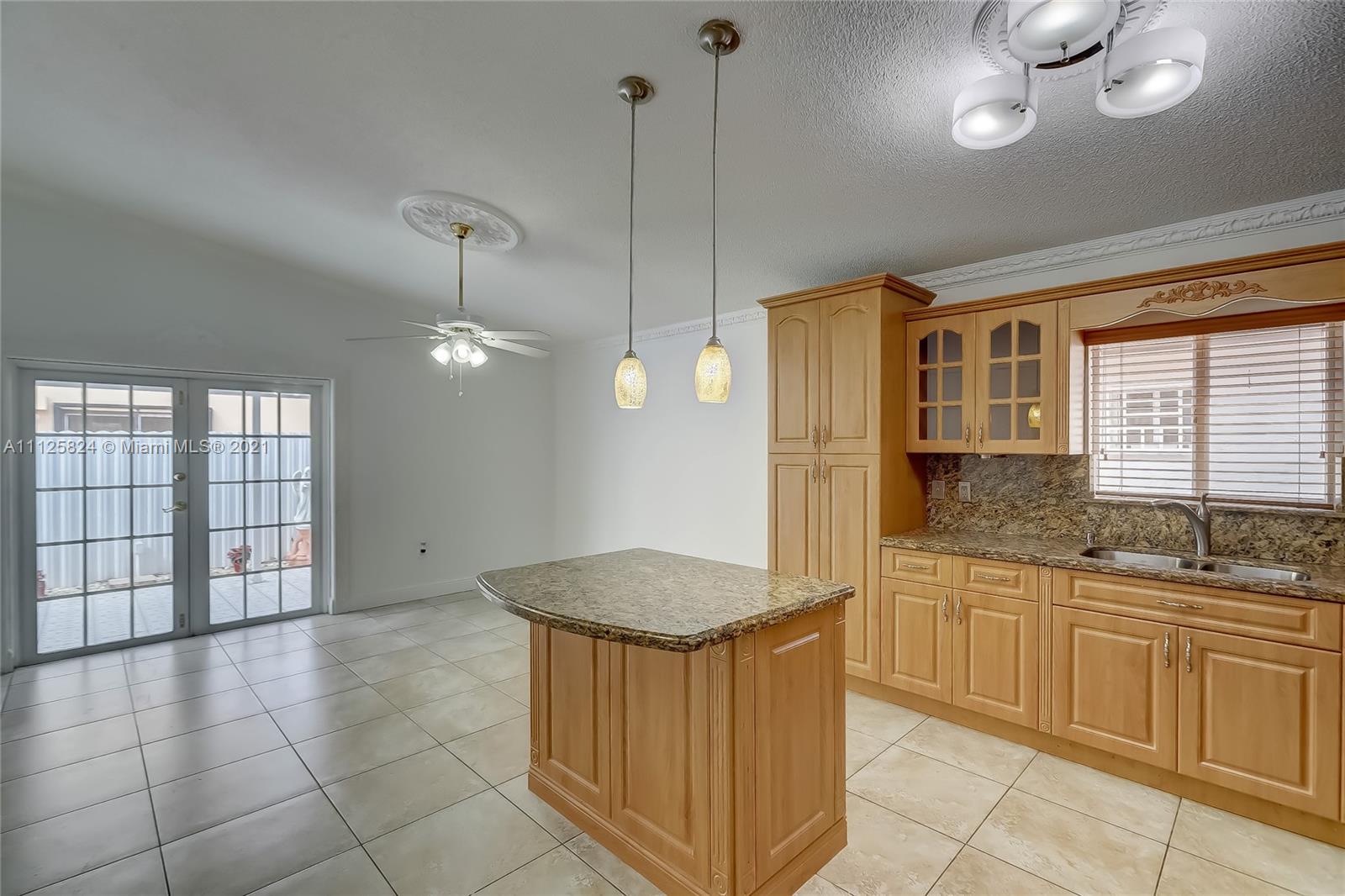 6858 West 30th Lane Hialeah, FL 33018 - Photo 15 of 37 a kitchen with granite countertop a sink a window and stainless steel appliances