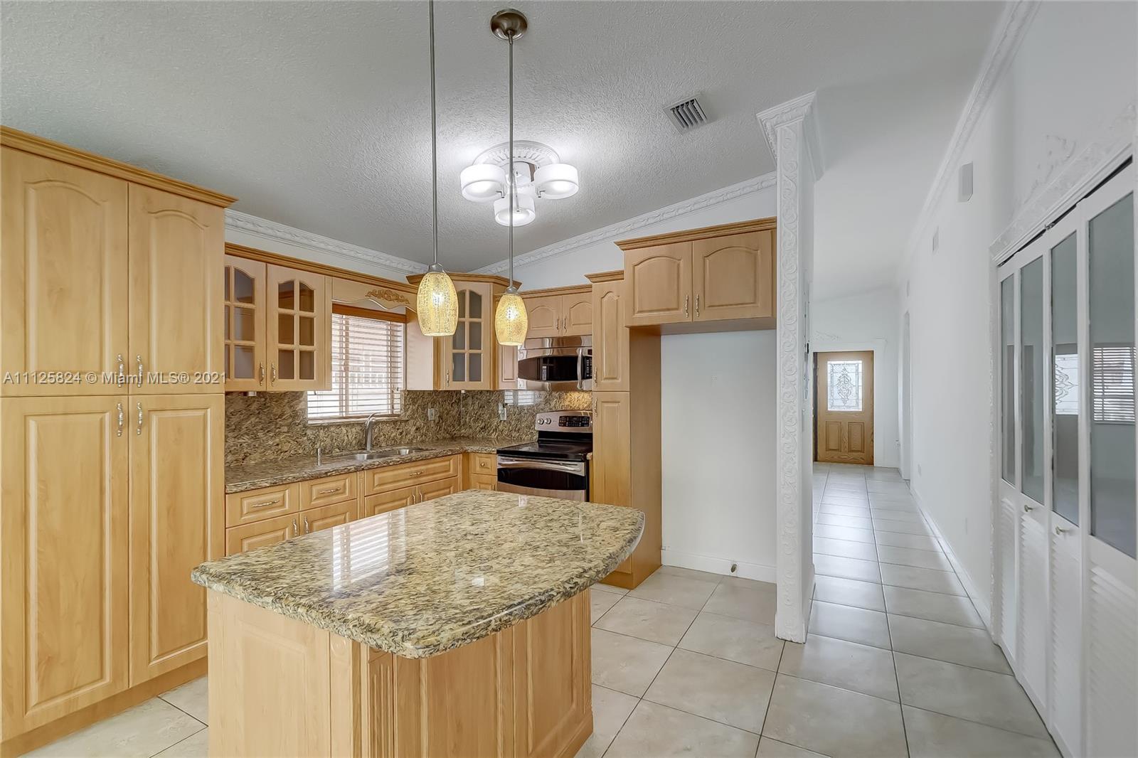 6858 West 30th Lane Hialeah, FL 33018 - Photo 16 of 37 a kitchen with granite countertop cabinets and refrigerator