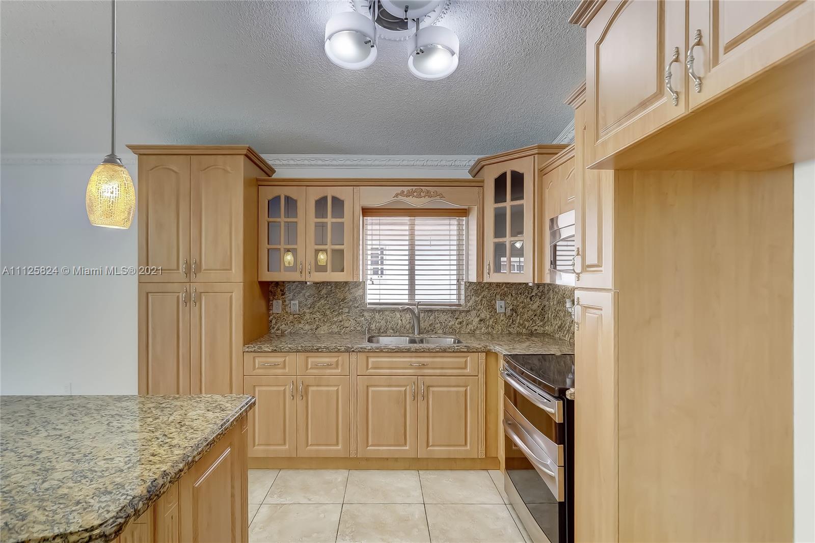 6858 West 30th Lane Hialeah, FL 33018 - Photo 17 of 37 a bathroom with a granite countertop sink a toilet and a mirror