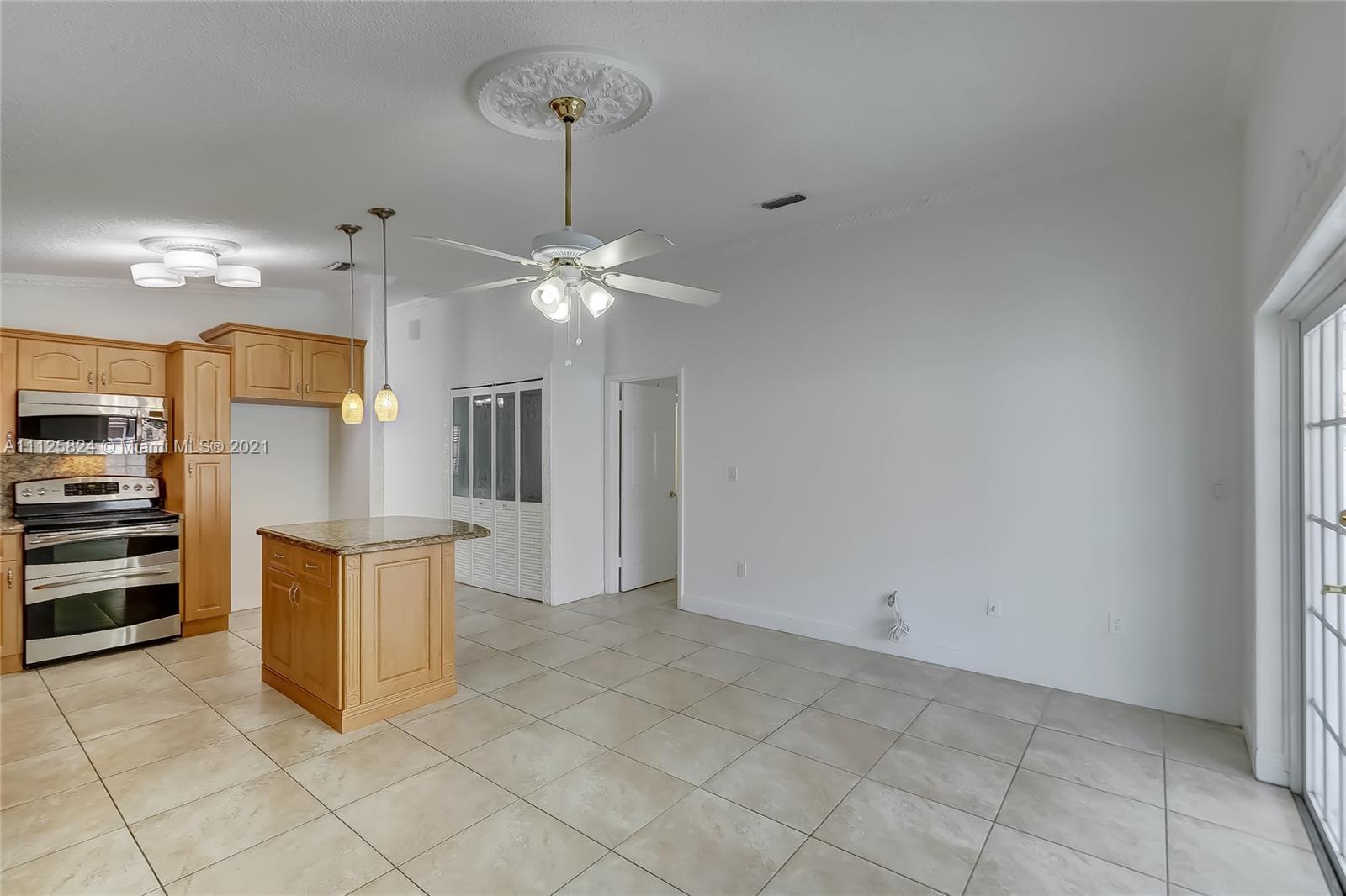6858 West 30th Lane Hialeah, FL 33018 - Photo 22 of 37 a kitchen with stainless steel appliances kitchen island granite countertop a refrigerator and a sink