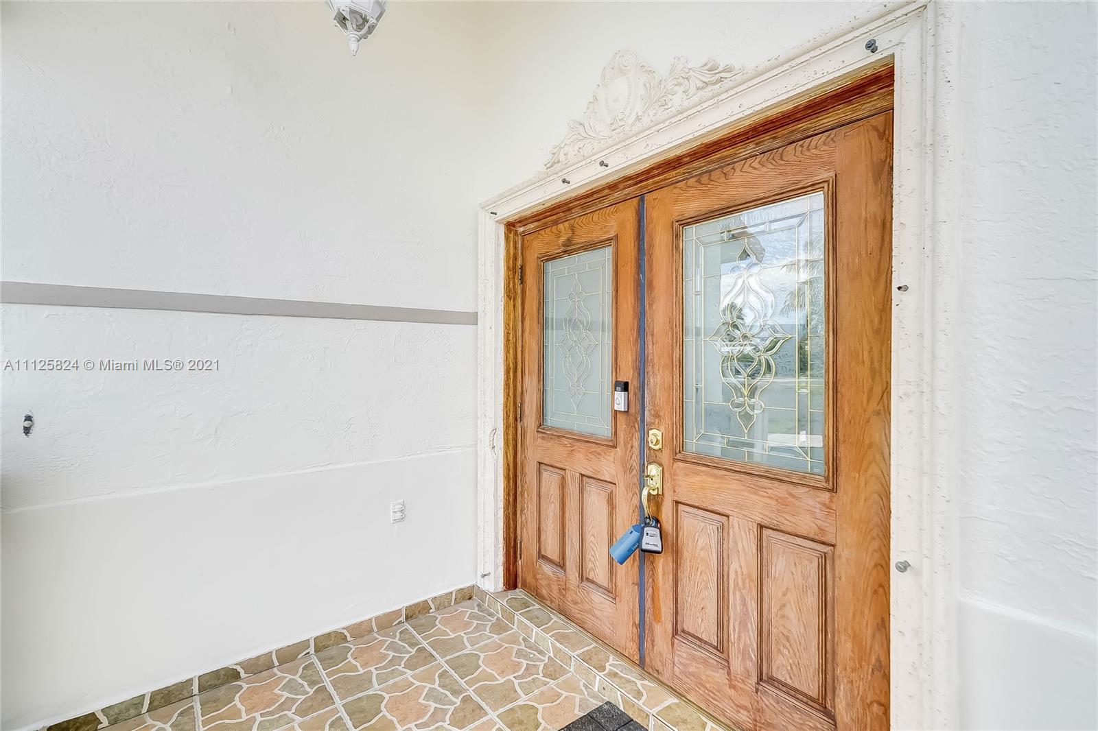 6858 West 30th Lane Hialeah, FL 33018 - Photo 4 of 37 a view of a hallway with wooden floor and a cabinet