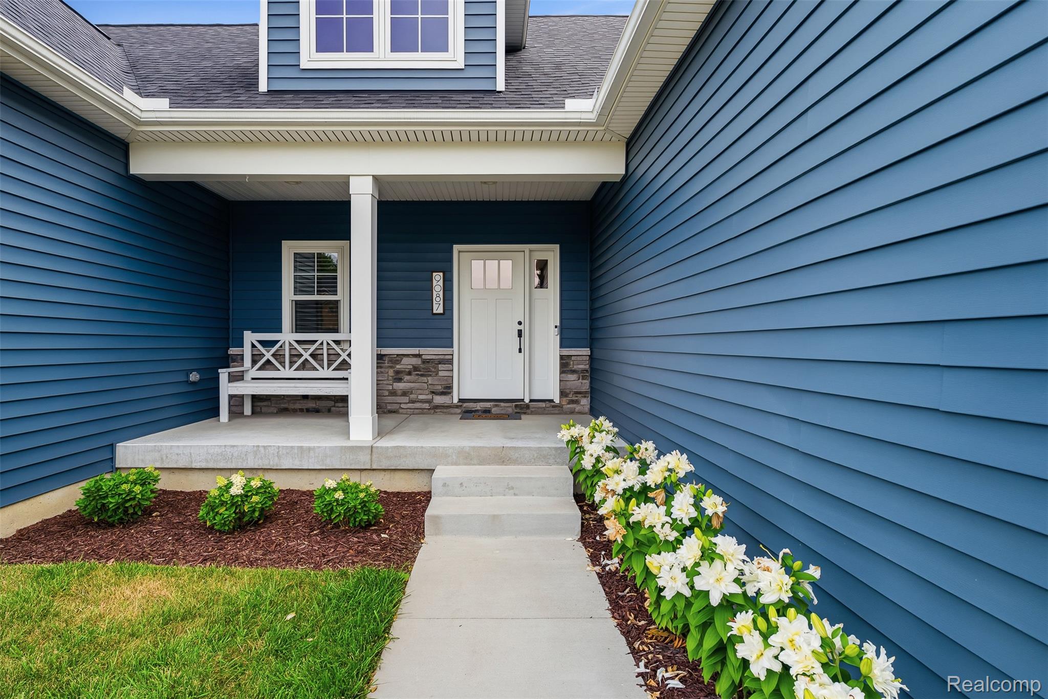 9087 Copper Ridge Drive Davison, MI 48423 - Photo 6 of 46 Property entrance featuring blue horizontal siding, a covered porch with white columns, and a white paneled front door