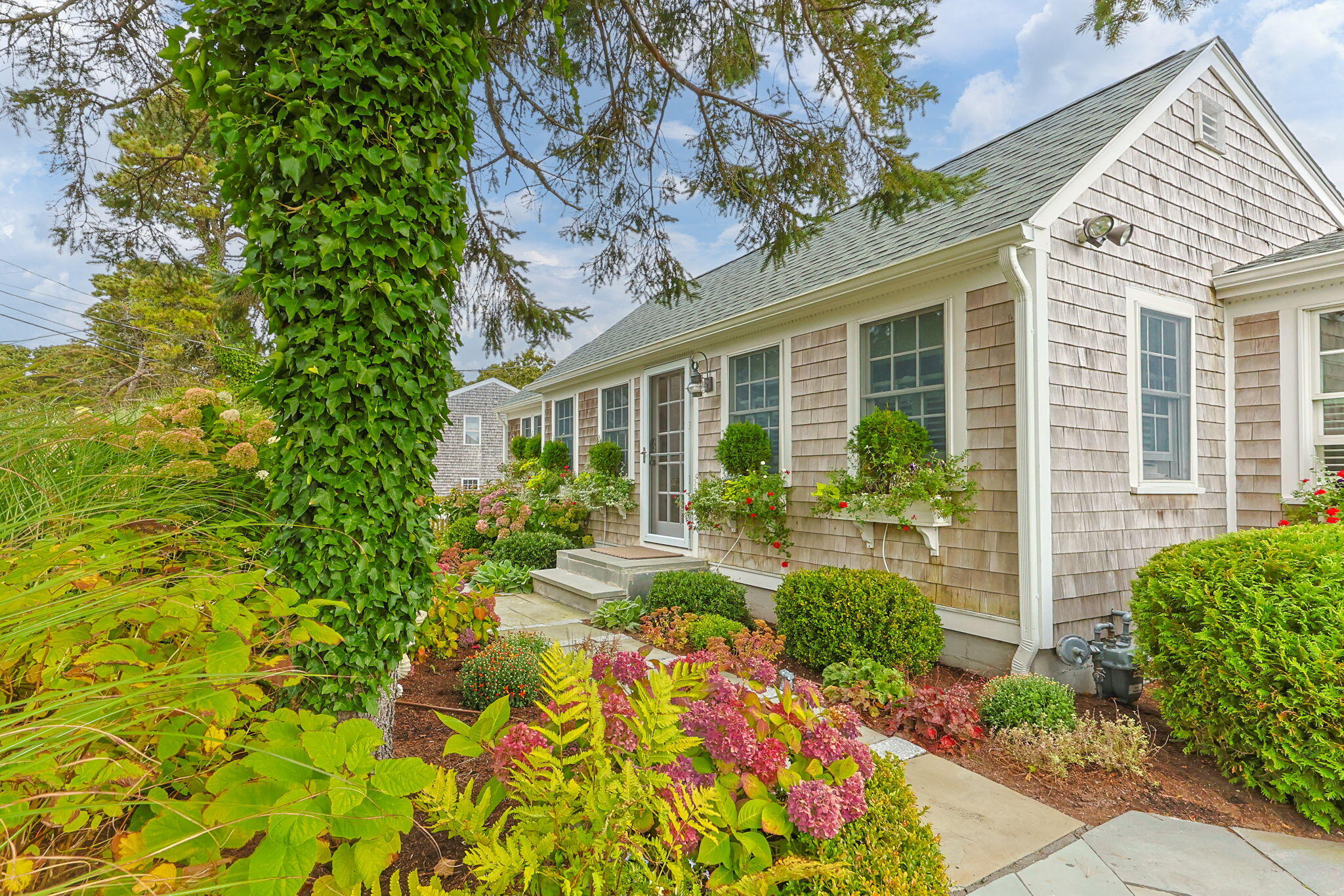291 Ridgevale Road Chatham, MA 02633 - Photo 9 of 53 a view of a house with potted plants and a fountain