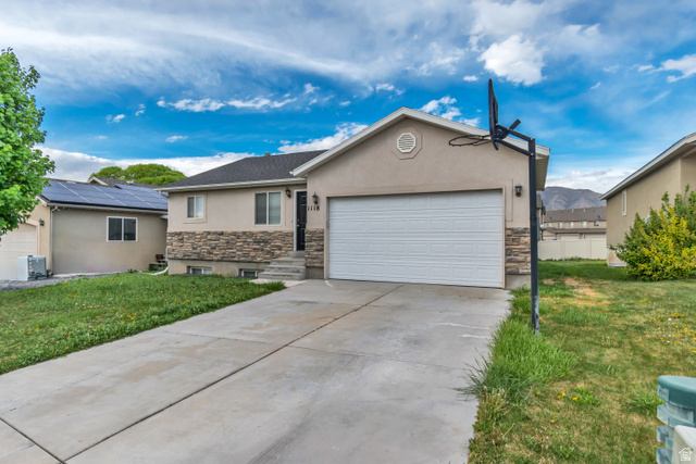 1118 North Ridge Court Spanish Fork, UT 84660 - Photo 2 of 32 Ranch-style house with stone siding, stucco siding, a garage, and a front lawn