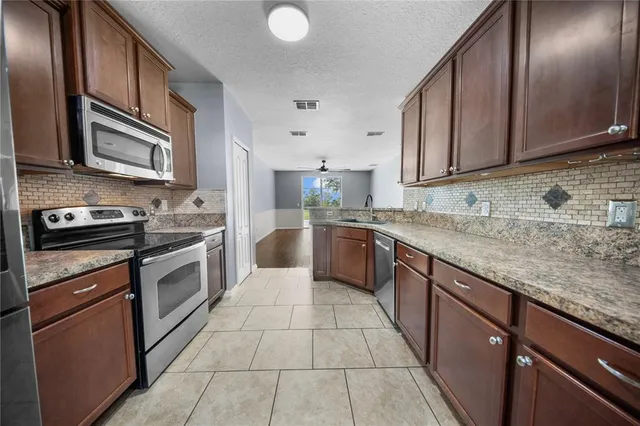 a kitchen with stainless steel appliances granite countertop a sink stove and cabinets