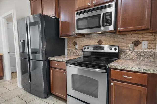 a kitchen with stainless steel appliances granite countertop a stove microwave and refrigerator