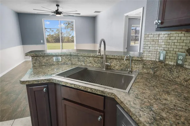 a kitchen with granite countertop a sink and a stove