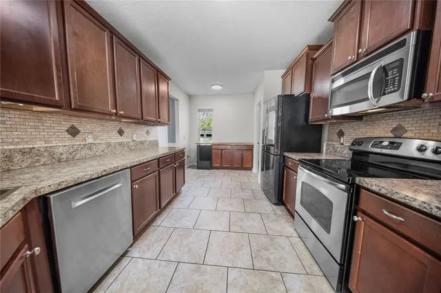 a kitchen with stainless steel appliances granite countertop a sink stove and cabinets