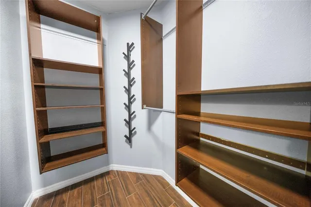 a view of walk in closet with empty racks