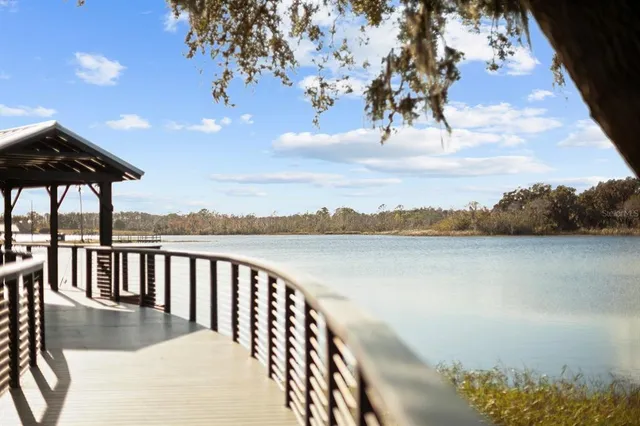 a view of a swimming pool with a lawn chairs under an umbrella