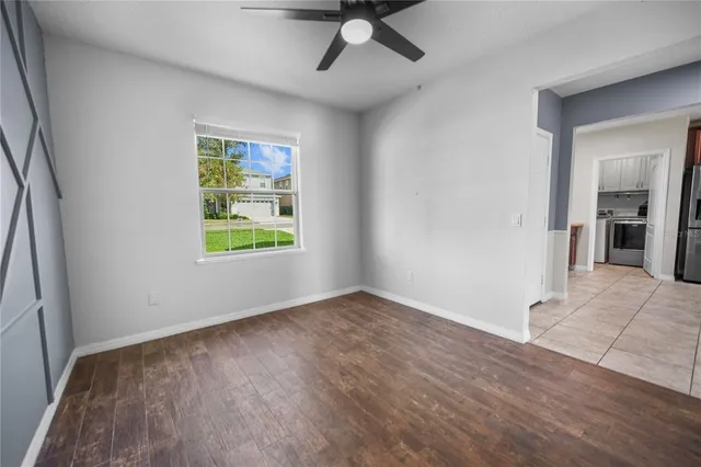 a view of an empty room with window and wooden floor