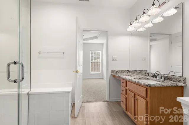 a bathroom with a granite countertop sink a mirror and shower