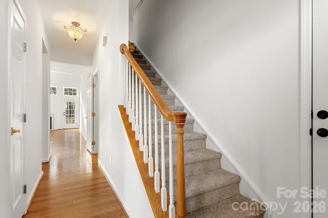 a view of a hallway with wooden floor and staircase