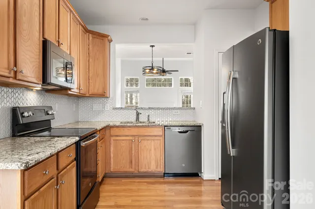 a kitchen with stainless steel appliances granite countertop a refrigerator and a sink